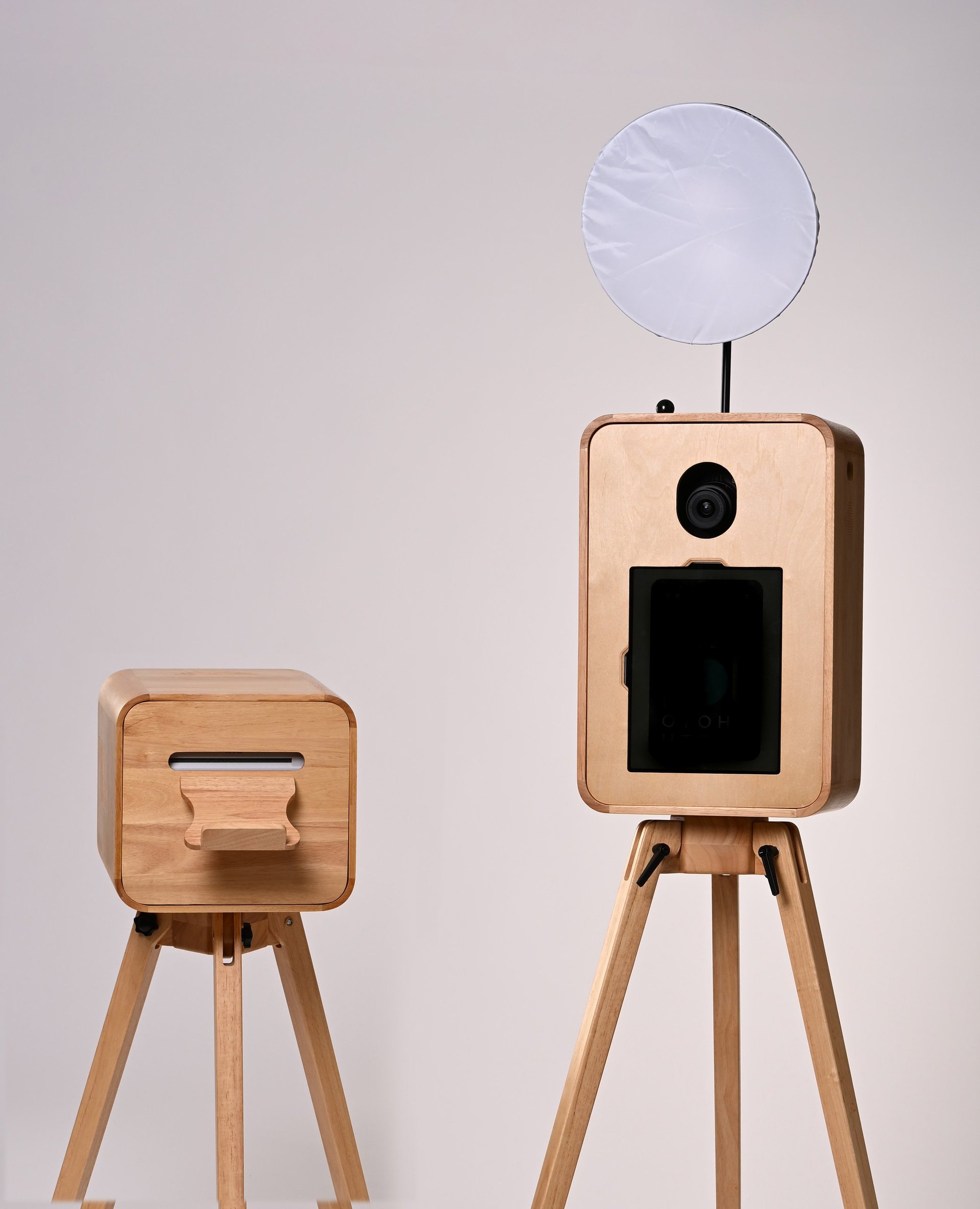 Two wooden photo booth structures with tripod legs and light balloon